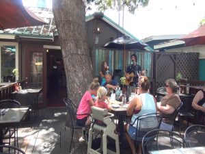Diners enjoy live music on the outdoor patio at Three's Bar & Grill. Photo by Kiaora Bohlool.