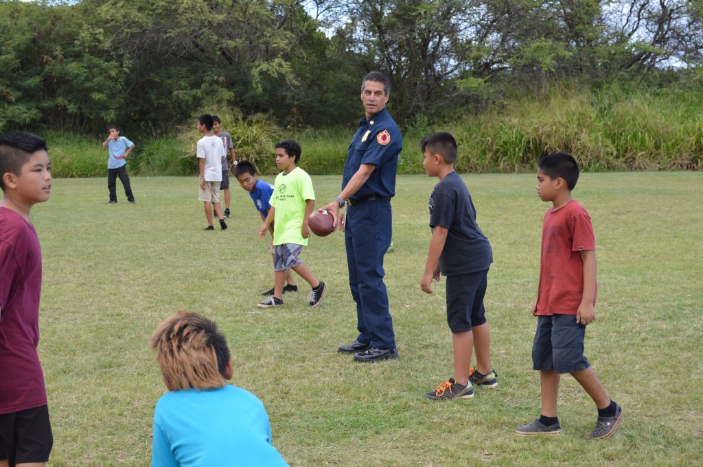 Maui Fire Chief Jeffrey Murray playing football with BGCM members. Photo credit: Boys & Girls Clubs of Maui.