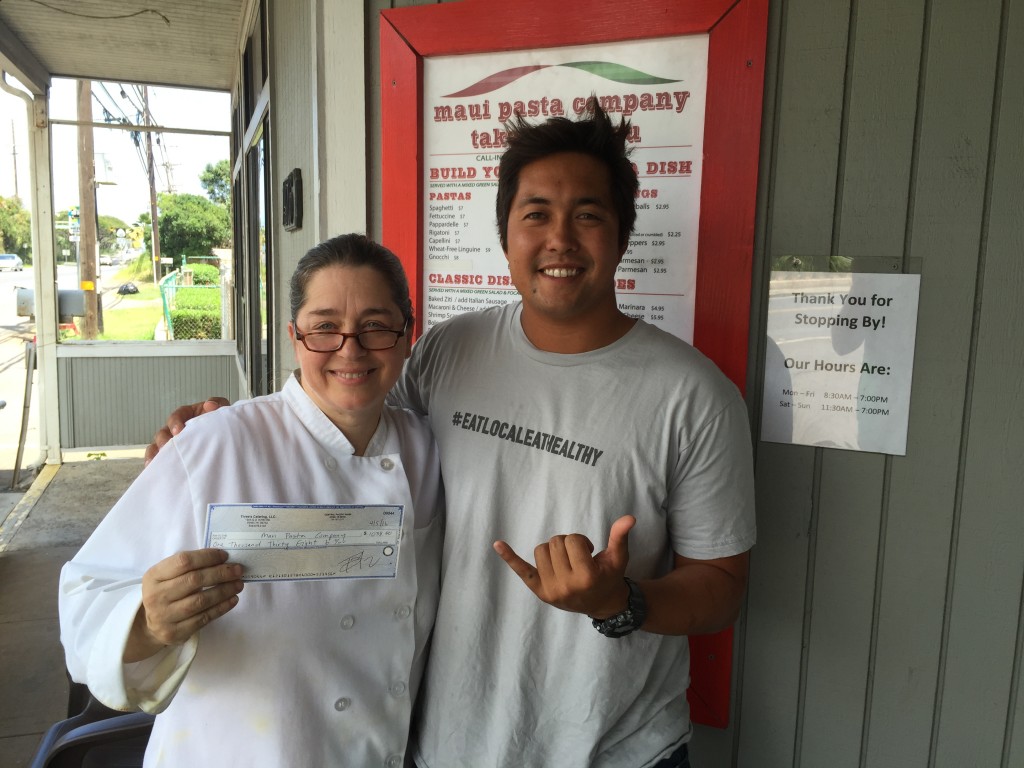 Travis Morrin Catering Director/Chef Co-Owner Three's Catering delivers a $1,038 check to Patricia Inman at Maui Pasta Co. as she faced unexpected financial hardship. Courtesy photo.
