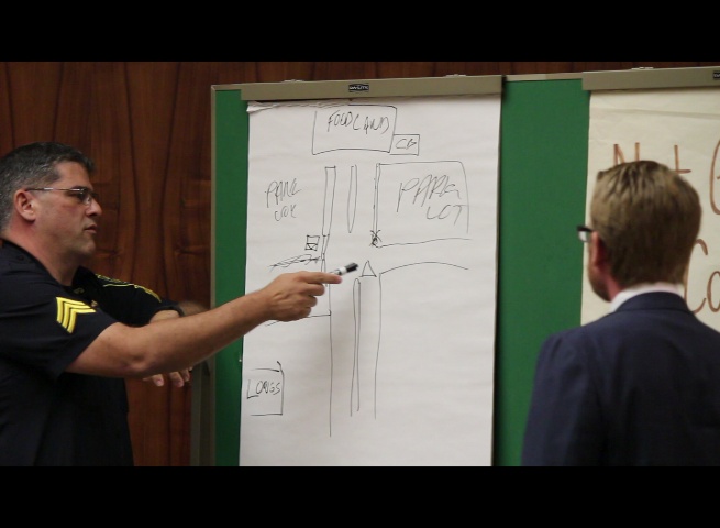 Defense attorney Samuel MacRoberts (right) asks Maui Police Sergeant Alan Brown (left) to draw a diagram of the Foodland parking lot where the police pursuit began. 