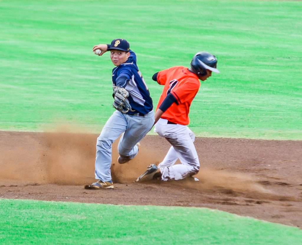 Punahou's Kekoa Vieira throws to first base for a double-play attempt after forcing out Campbell's Darien Robinson at second base. Photo by Rodney S. Yap.