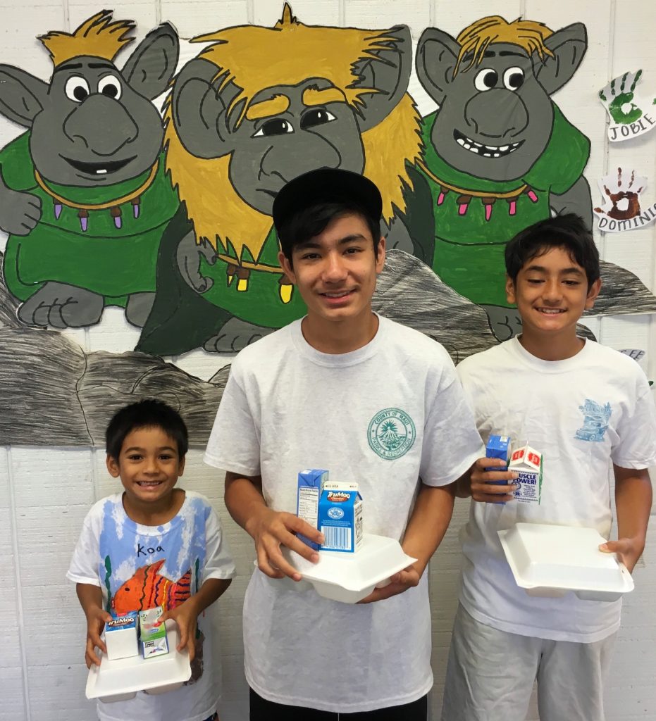 Three brothers from KCC PALS enjoy their meal: Koa (Kindergarten), Nalu (5th and Up) and Pono Akiona, a PALS volunteer. Photo credit: County of Maui, Dept. of Parks and Recreation (Ryan Min).