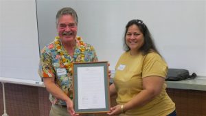 Outgoing NHOM President Dawn DeRego presented John Andersen, Na Hale O Maui’s principal broker and former executive director, with a board resolution recognizing him as an instrumental founding NHOM member and for his years of dedicated service and commitment. NHOM photo.