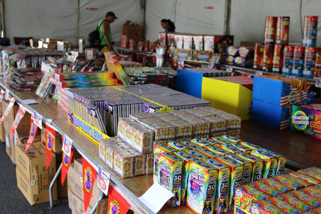 Customers looking at novelty fireworks at the Phantom Fireworks Tent at Queen Kaʻahumanu Center. Photo: Nicole Schenfeld
