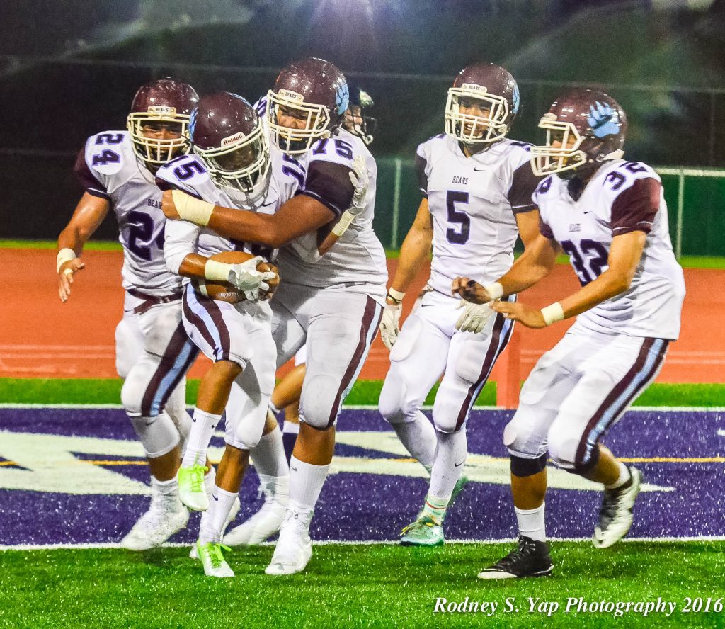 Baldwin's Dalton Mata (15) celebrates with teammates, including Gavin Arista (75), after hauling in for a 36-yard scoring toss with 36 seconds left before halftime. Photo by Rodney S. Yap.