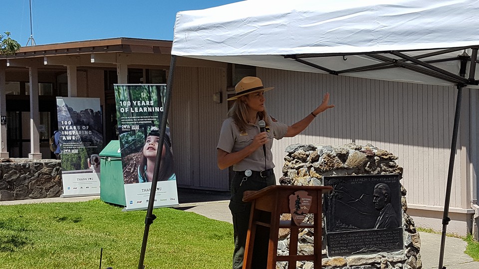Superintendent Natalie Gates asks visitors to share their favorite park memories. She is standing next to a plaque honoring Stephen Mather, the first National Park Service Director.