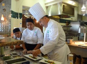 Chef Tom Lelli instructing how to plate salad at UHMC's restaurant. Courtesy photo.