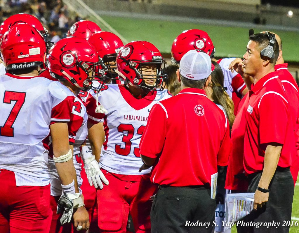 Lahainaluna offensive coordinator Garret Tihada (right) talks to his offensive personnel during a timeout Saturday against Kamehameha Maui. Photo by Rodney S. Yap.