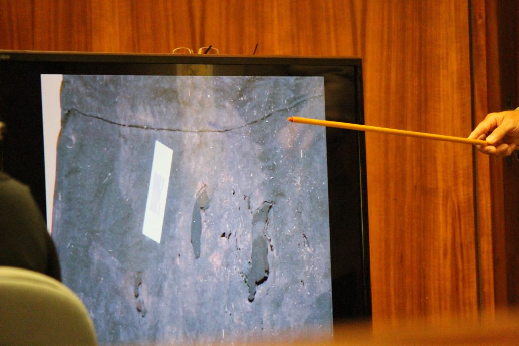 Anthony Earls, evidence specialist with the Maui Police Department describes holes and staining observed on a black skirt recovered from Nuaʻailua Bay. Photo by Wendy Osher.