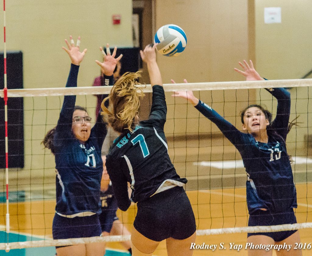 King Kekaulike junior outside-hitter Chandler Cowell puts down one of her match-high 11 kills. Trying to defend on the play are Kamehameha Maui's Logan Spencer (11) and Kylee Yamashita. Photo by Rodney S. Yap.