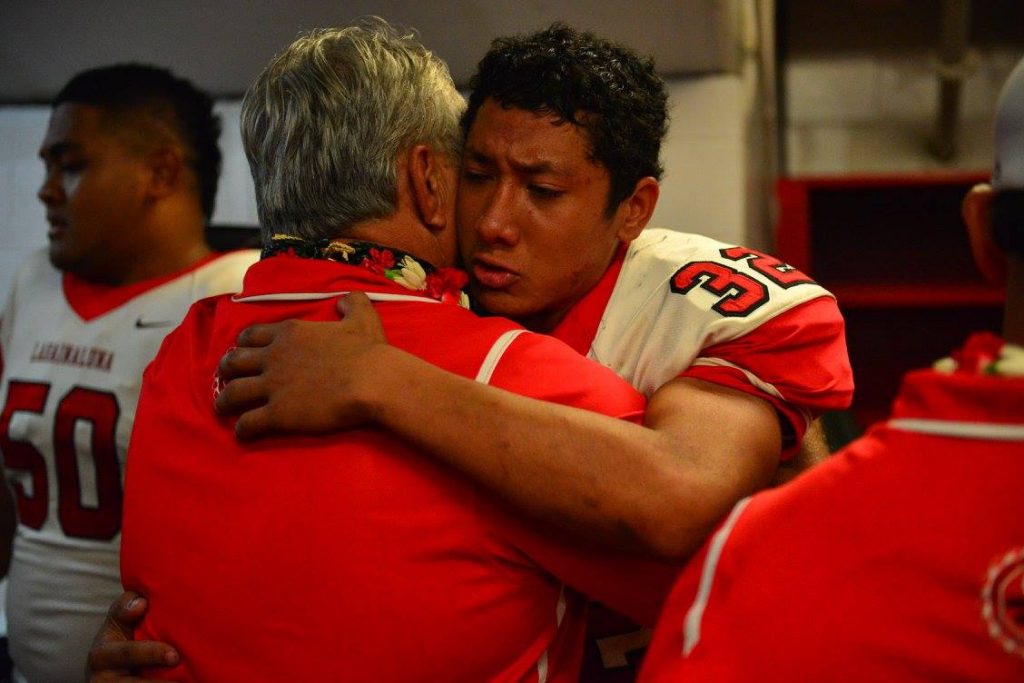 Lahainaluna co-head coach Bobby Watson shares a moment with senior Josaiah Sombelon-McEwen, who had five tackles in the championship game against Kapaa, including one sack for minus 8 yards. Photo by Glen Pascual.